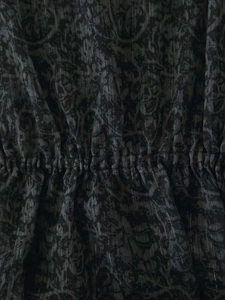 Detalle de la cintura elástica de un vestido damasco oscuro con hilos de plata brillo