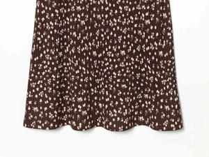 Detailed macro view of dark brown pleated fabric with white floral print texture