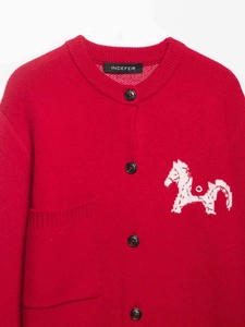 Detail shot of a red knit cardigan with horse embroidery and black buttons