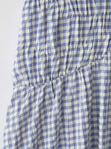Nahaufnahme von blau-weißem Gingham-Stoff mit gerafften Details und Textur-Lagen