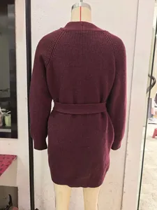 Detail of burgundy chunky knit cardigan with matching belt and textured knit pattern
