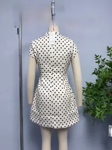 Detailed view of white polka dot short dress with bow tie collar on a mannequin