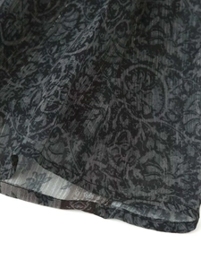 Detalle de tela gris oscuro con patrones circulares vintage y textura de rayas verticales
