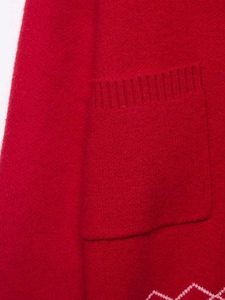 Détail du cardigan en maille rouge avec poche plaquée et motif jacquard à vagues blanches