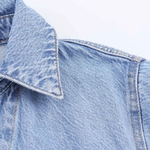 Close-up of light blue denim shirt collar with detailed stitching and twill texture