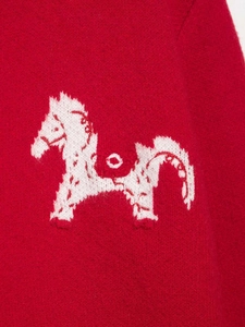 Detail of red knit cardigan featuring a white jacquard horse pattern with intricate textures