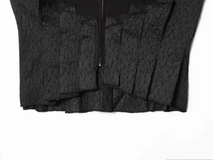 Macro detail of charcoal black pleated texture corset with central metal zipper closure