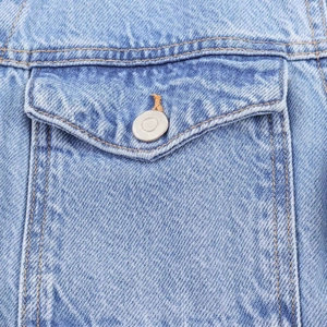 Detail showing high-quality light blue denim fabric texture and orange contrast stitching