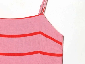 Dettaglio dell'abito estivo a righe rosa e rosse con spallina regolabile e fibbia in metallo