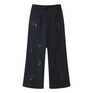 Detailed close-up of distressed striped trousers with ragged patch pockets and raw edges