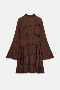 Detail of the layered ruffle hem and crepe texture on a brown satin mini dress