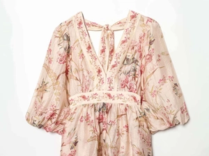 Detailed view of deep V-neckline and delicate floral print on summer dress fabric
