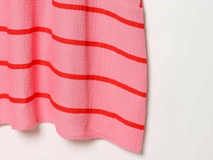 Dettaglio di mussola di cotone a righe rosa e rosse con trama naturale stropicciata