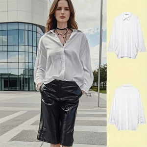 Close-up of white vertical striped long sleeve shirt with polished black PU leather shorts