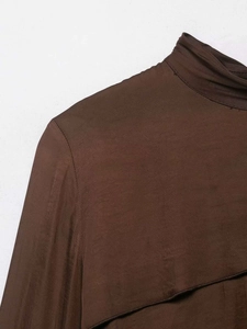 Detail view of dark brown high collar top featuring premium silk-satin texture