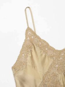 Gros plan sur le tissu en satin champagne et la broderie en dentelle sur l'encolure