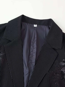 Detail of sequined floral embroidery on black pinstripe blazer with size label