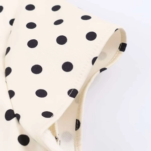 Detail view of polka dot fabric with precise stitching on a stylish summer dress sleeve