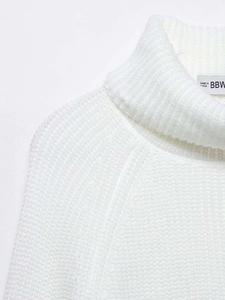 Close-up of white turtleneck sweater showing waffle knit texture and neckline seam