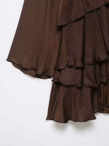 Detail of dark brown satin dress with layered ruffles and delicate rolled hem finish