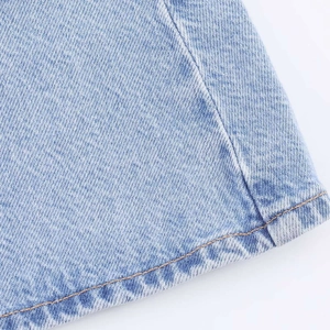Detail of light blue denim fabric with reinforced double stitching on the hemline