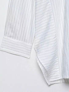 Detail of pinstripe shirt showing striped texture and seamless cuff stitching