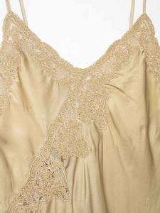 Détail du caraco en satin champagne avec dentelle délicate et fines bretelles de luxe