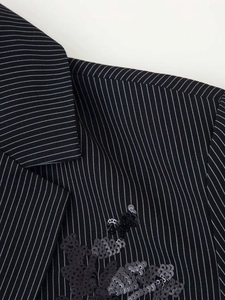 Detail view of black pinstripe blazer featuring intricate floral sequin embroidery details