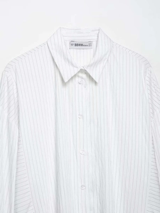 Detailed macro shot of classic turn-down collar and brand label on white striped shirt