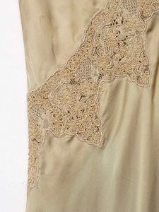 Gros plan sur le tissu satiné doré champagne avec broderie de dentelle florale