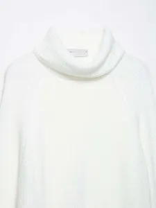 Detailed macro view of waffle knit texture and ribbed high collar on off-white sweater