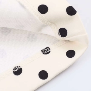 Close-up of black polka dot print on soft fabric with durable double-needle stitching