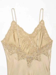 Détail d'une robe en satin champagne avec dentelle florale et fines bretelles