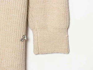 Detail of oatmeal knit cardigan with ribbed cuffs and decorative crystal charms