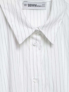 Detailed close-up of classic pointed collar and black vertical stripes on white shirt