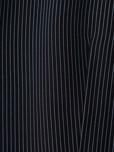Close-up of black suit fabric featuring dense white pinstripe texture and premium material