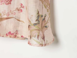 Detailed close-up of floral print chiffon fabric with soft pink flowers and green leaves