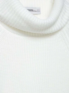 Close-up of ribbed turtleneck design and soft knit texture on white sweater