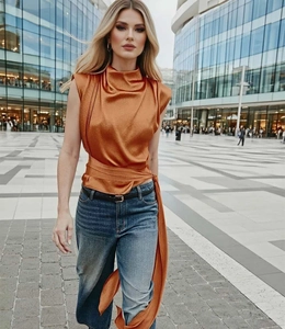 Detail of burnt orange satin sleeveless top with a high neckline and waist tie detail