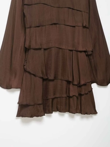 Detailed view of layered ruffles and satin texture on a dark brown mini dress