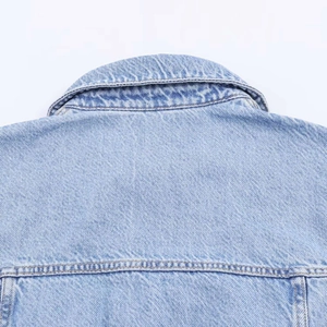 Detail view of denim dress collar with yellow contrast stitching and washed blue texture