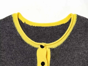 Close-up of contrast crew neck grey knit cardigan with yellow trim and black buttons