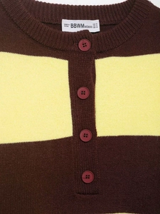 Close-up of contrast striped knit sweater featuring a buttoned collar and soft ribbed texture