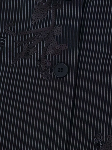 Detail of black pinstripe blazer featuring exquisite leaf-patterned sequin embroidery