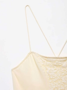 Detail of cross-back straps and delicate lace patchwork on an asymmetric summer dress
