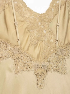 Détail d'un caraco en satin doré champagne avec dentelle florale et bretelles réglables