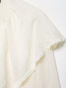 Gros plan sur le tissu texturé blanc avec bordure en dentelle de la chemise