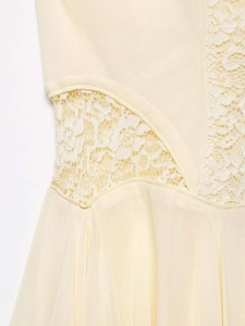 Close-up of beige summer dress with floral lace stitching and delicate woven fabric