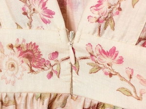 Detailed close-up of invisible zipper on floral waist of summer dress fabric