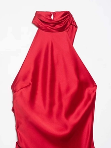 Detail of red satin halter dress showing pleated high neck and silky fabric texture